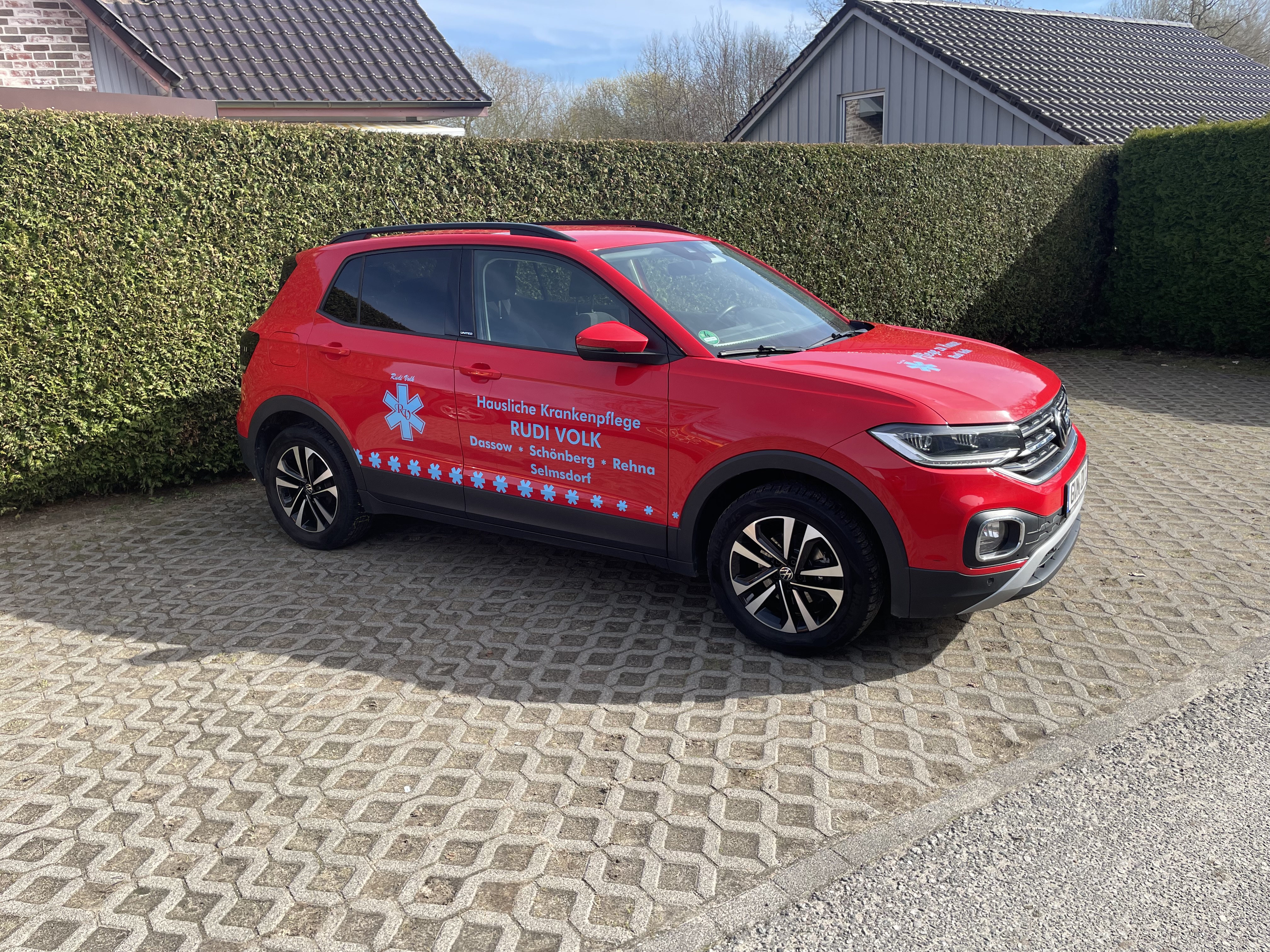 Firmenwagen der Häuslichen Krankenpflege Rudi Volk – ein roter PKW mit Logo